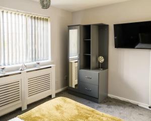 a living room with a tv and a entertainment center at Stylish Two-bed House Birmingham sleep up-to 6 in Birmingham