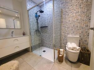 a bathroom with a glass shower and a toilet at EF7 Beds & Family in Tarragona