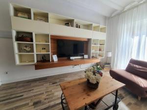 sala de estar con TV, mesa y sofá en EF7 Beds & Family, en Tarragona