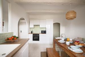 a kitchen with white cabinets and a wooden counter top at Les Remparts de Vence in Saint Paul de Vence