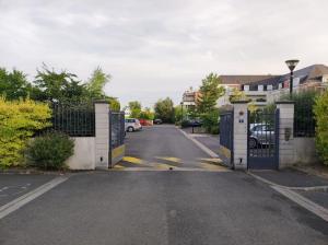 an empty street with a gate and a parking lot at Voyage en Touraine in Fondettes