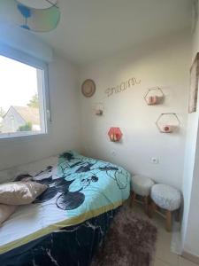 a bedroom with a bed and a window at Voyage en Touraine in Fondettes