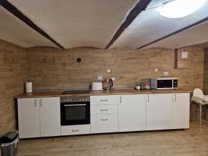 a kitchen with white cabinets and a counter top at Casa 7 SATE apartament in Săcele