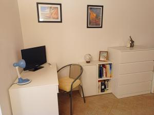 パレルモにあるCasa Peppyのデスク、パソコン、椅子が備わる客室です。