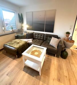 ein Wohnzimmer mit einem Sofa und einem Couchtisch in der Unterkunft Auszeit Norddeich mit Seeblick in Norddeich