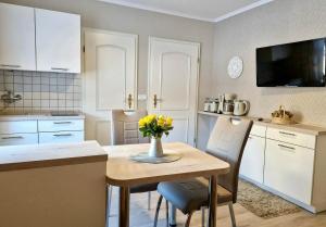 a kitchen with a table with a vase of flowers on it at Fuchsbau in Schwedt