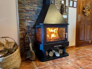 a stove in a living room with a fireplace at La casita del pueblo in Fondón