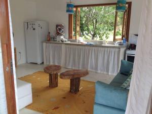 聖克魯斯－卡布拉利亞的住宿－Casa charmosa na Praia de Santo Andre/ Bahia，厨房配有一张桌子和两张凳子