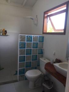 La salle de bains est pourvue de toilettes, d'un lavabo et d'une fenêtre. dans l'établissement Casa charmosa na Praia de Santo Andre/ Bahia, à Santa Cruz Cabrália