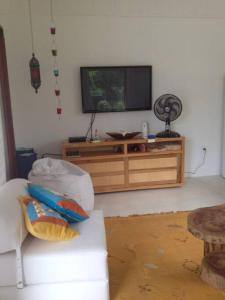 een woonkamer met een televisie en een bank bij Casa charmosa na Praia de Santo Andre/ Bahia in Santa Cruz Cabrália