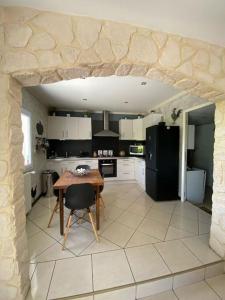 una cucina con tavolo e frigorifero nero di Maison chaleureuse aux portes de Tours. a Saint-Branchs