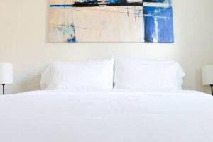 uma cama com duas almofadas e um quadro por cima em Sunny 3 Bedroom 3 Bath Retreat in Fort Lauderdale em Fort Lauderdale