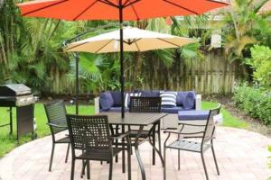 uma mesa de pátio e cadeiras com um guarda-sol em Sunny 3 Bedroom 3 Bath Retreat in Fort Lauderdale em Fort Lauderdale