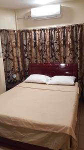 a bed in a room with a curtain and a bed sidx sidx sidx at Loidas place in Talisay