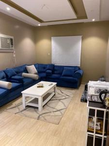 a living room with a blue couch and a white coffee table at Alfatih apartments شقة الفتح in Al Madinah