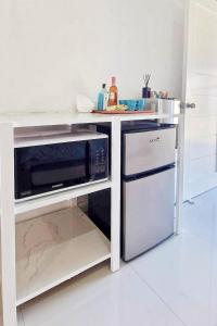 a kitchen with a counter with a microwave and a dishwasher at Ina Rose Apartment and Transient 