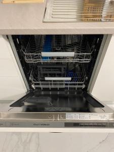 an open dishwasher with dishes inside of it at Luxury House Bergamo vicino aeroporto Orio e Ospedale Papa Giovanni XXIII in Curno