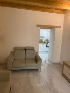 a living room with a couch and a kitchen at Luxury House Bergamo vicino aeroporto Orio e Ospedale Papa Giovanni XXIII in Curno