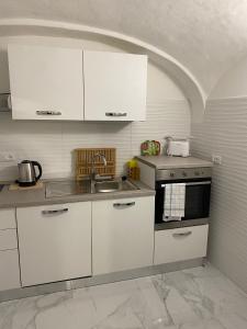 a kitchen with white cabinets and a sink at Luxury House Bergamo vicino aeroporto Orio e Ospedale Papa Giovanni XXIII in Curno