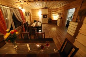 a dining room with a table and chairs in a cabin at Sowi Gościniec Wellness & Breakfast in Sokolec