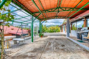 eine geschlossene Terrasse mit einem Tisch und einem Herd in der Unterkunft Arenal Chill Inn in Nuevo Arenal