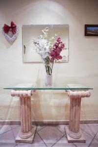 a glass table with a vase of flowers on it at La Casetta sul Lago in Castel Gandolfo