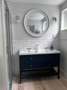a bathroom with a sink and a mirror at Efail Fach in New Quay