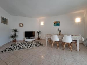 - un salon avec une table, des chaises et une télévision dans l'établissement Grand T2 proche centre ville, vue mer et montagne, à Bastia