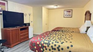 a hotel room with a bed and a flat screen tv at Budget Inn Express in South Hill