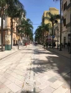 an empty street with palm trees in a city at My Cozy Home in Brindisi