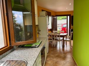 a kitchen and dining room with a table and chairs at Apartamento de Pascualin con jardin privado in A Coruña