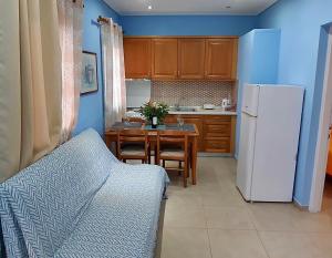 科孚镇Angela Corfu的厨房里有一张桌子和一台白色冰箱