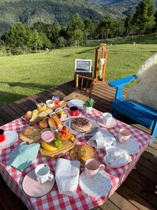 a picnic table with food on a checkered table cloth at Cabana Fortaleza - Pousada Colina dos Ventos in Urubici