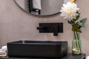 un évier noir avec un vase de fleurs sur un comptoir dans l'établissement Suite Bermeo - Loft, à Bermeo