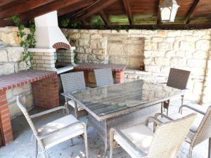 a patio with a table and chairs and an outdoor oven at Villa Musica in Balchik