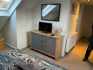ein Wohnzimmer mit einem TV auf einer Kommode mit in der Unterkunft Glenashdale 28 A 1/R Boyd Street Largs KA308LE in Largs