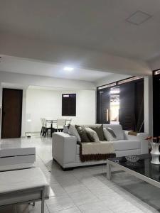 un soggiorno con divano bianco e tavolo di Bangalô no condomínio Victory em Lucena-PB a Lucena