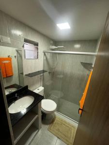 W łazience znajduje się toaleta, umywalka i prysznic. w obiekcie Bangalô no condomínio Victory em Lucena-PB w mieście Lucena