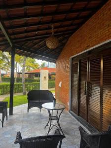 盧塞納的住宿－Bangalô no condomínio Victory em Lucena-PB，庭院设有带椅子和桌子的庭院。