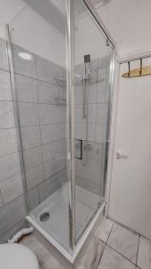 a shower with a glass door in a bathroom at Gatesden Guest House in London