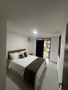 een slaapkamer met een groot bed in een kamer bij Bangalô no condomínio Victory em Lucena-PB in Lucena