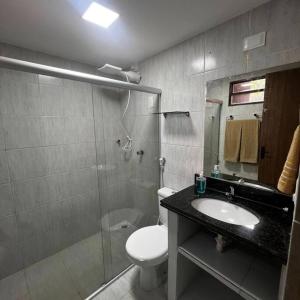 e bagno con servizi igienici, lavandino e doccia. di Bangalô no condomínio Victory em Lucena-PB a Lucena