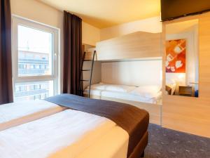 シュトゥットガルトにあるB&B Hotel Stuttgart-Bad Cannstattのベッドルーム1室(二段ベッド2台、窓付)が備わります。
