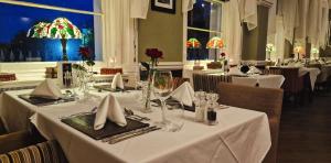 un comedor con mesas con manteles y sillas blancas en The Osborne Hotel, en Torquay