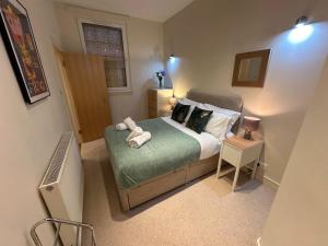 sypialnia z łóżkiem z ręcznikami w obiekcie Apartment Thistle Lane w Edynburgu