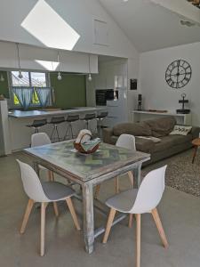 cocina y sala de estar con mesa y sillas en la Villa des Cigales, en Coudeville