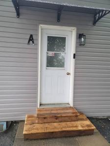 a house with a white door with a window at Warm cozy 1 bdrm close to Hwy in Edmundston