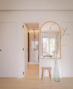 a room with a mirror and a wooden stool at Apartamento de diseño en Pozuelo in Pozuelo de Alarcón