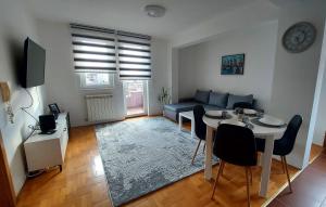 ein Wohnzimmer mit einem Tisch und einem blauen Sofa in der Unterkunft Apartman Ady in Novi Pazar