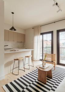 una cucina e un soggiorno con tavolo e sedie di Apartamento de diseño en Pozuelo a Pozuelo de Alarcón
